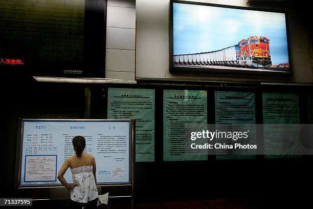 Passenger reads a billboard for the Qinghai-Tibet railway at Beijing West Railway Station, on June 28, 2006 in Beijing, China. The Qinghai-Tibet...