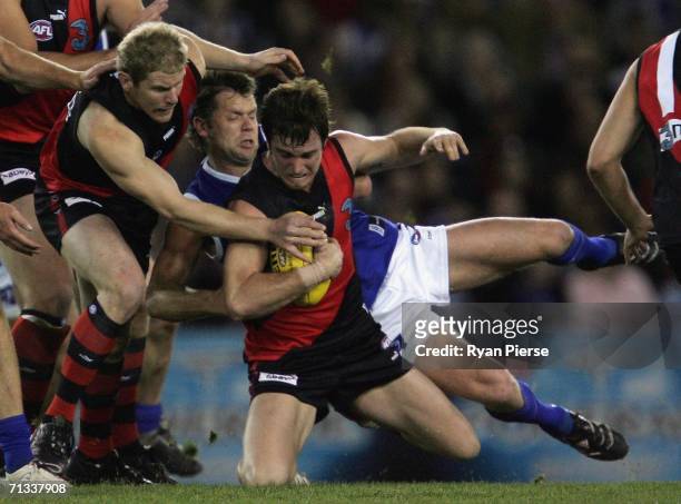 Glenn Archer of the Kangaroos tackles Andrew Welsh of the Bombers during the round thirteen AFL match between the Kangaroos and Essendon Bombers at...