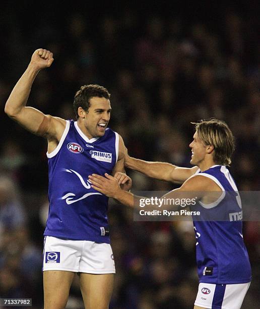 Ben Schwarze and Jess Sinclair of the Kangaroos celebrate a goal during the round thirteen AFL match between the Kangaroos and Essendon Bombers at...