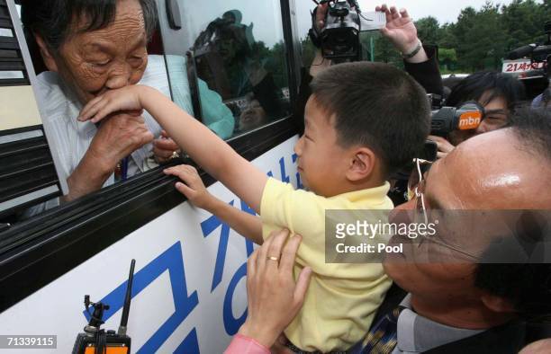 South Korean Choi Gye-Wol kisses the hand of her grandson Kim Chol-Bong as her son Kim Young-Nam watches, before she returns to her South Korean home...