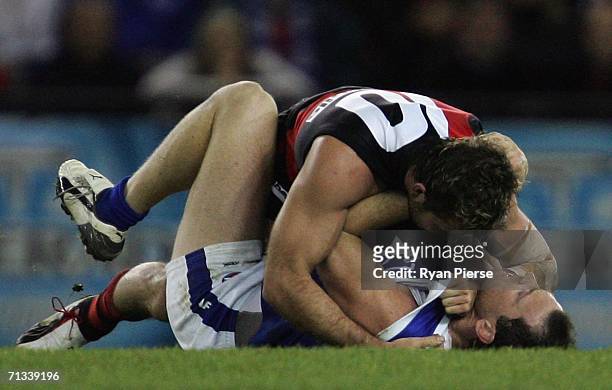 Mark McVeigh of the Bombers clashes with Adam Simpson of the Kangaroos during the round thirteen AFL match between the Kangaroos and Essendon Bombers...