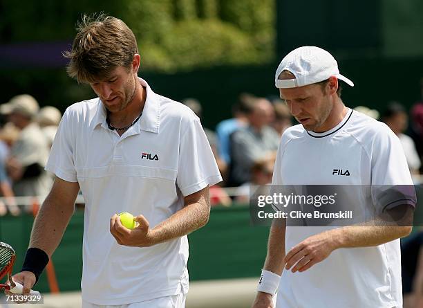 Michael Kohlmann and Rainer Schuettler of Germany walk back to the base line in their match against Kevin Ullyett of Zimbabwe and Paul Hanley of...