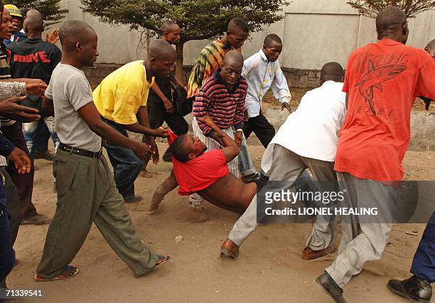 Man is dragged and injured during a demonstration in the streets of Kinshasa, 30 June 2006. A major dialogue involving the political elite of the...