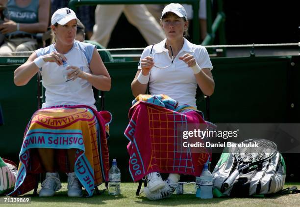 Samantha Stosur of Australia and Lisa Raymond of The United States take a break between games in their match against Abigail Spears and Amy Frazier...