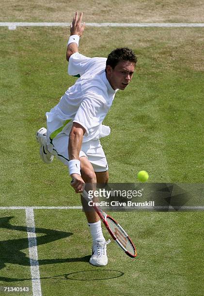 Nicolas Mahut of France returns a backhand to Roger Federer of Switzerland during day five of the Wimbledon Lawn Tennis Championships at the All...