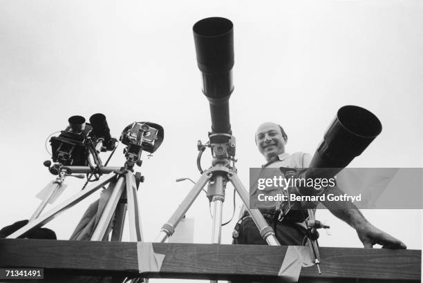 American photojournalist Yale Joel poses with several cameras with telescopic lenses, 1960s.