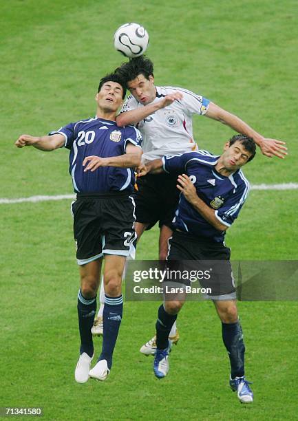 Michael Ballack of Germany collides in the air with Julio Cruz and Javier Mascherano of Argentina during the FIFA World Cup Germany 2006...