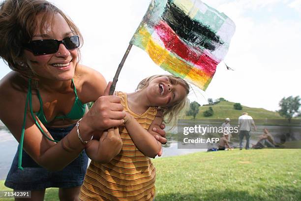 German woman and her daughter hold their national flag at a park in Munich 30 June 2006 after their team's victory over Argentina during their...