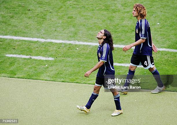 Juan Sorin and Fabricio Coloccini of Argentina dejectedly leave the pitch following their team's defeat in a penalty shootout at the end of the FIFA...