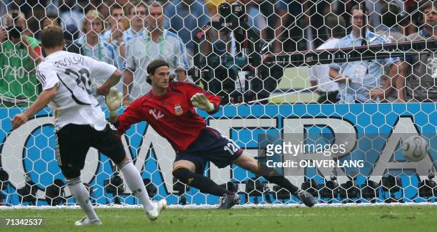 German forward Lukas Podolski scores against Argentinian goalkeeper Leonardo Franco during a penalty shootout at the end of the quarter-final World...