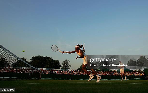 Venus Williams of the United States hits a volley while playing with doubles partner Bob Bryan of the United States against Jeff Coetzee of South...