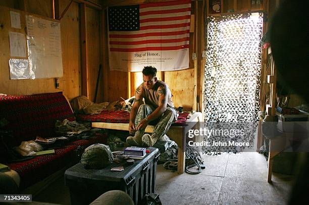 Army Spc. Ryan Taylor puts on his boots at an American base at Deh Afghan on June 30, 2006 in the Zabul province of southern Afghanistan. Some 10,000...