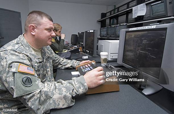 Army Specialist Shenandoah Rogers, of the Arizona National Guard?s 180th Field Artillery unit, works his computer's joy stick controlling a remote TV...