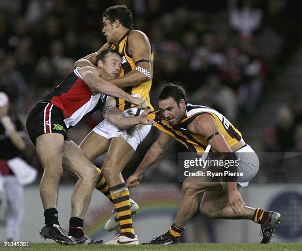 Brent Guerra and Lance Franklin of the Hawks clash with Max Hudghton of the Saints during the round 13 AFL match between the St Kilda Saints and the...