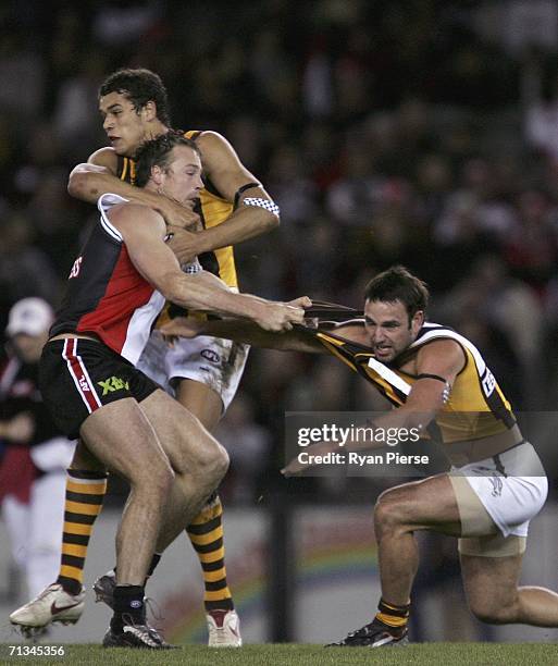 Brent Guerra and Lance Franklin of the Hawks clash with Max Hudghton of the Saints during the round 13 AFL match between the St Kilda Saints and the...