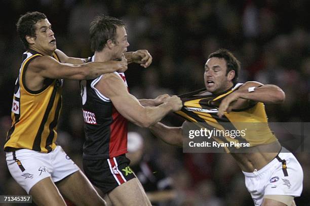 Brent Guerra and Lance Franklin of the Hawks clash with Max Hudghton of the Saints during the round 13 AFL match between the St Kilda Saints and the...