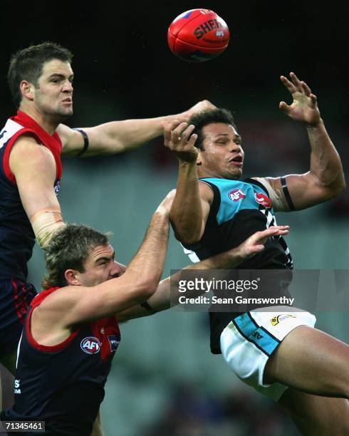 Jared Rivers, Nathan Carroll for Melbourne and Daniel Motlop for the Power in action during the round 13 AFL match between Melbourne and Port...
