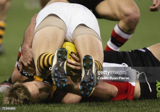 Sam Mitchell of the Hawks is tackled during the round thirteen AFL match between the St Kilda Saints and the Hawthorn Hawks at the Telstra Dome July...