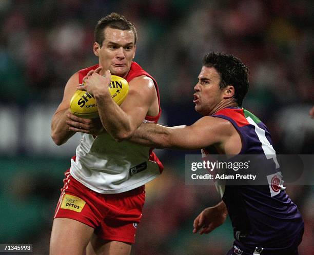 Amon Buchanan of the Swans is tackled during the AFL Round thirteen match between the Sydney Swans and the Fremantle Dockers at the Sydney Cricket...