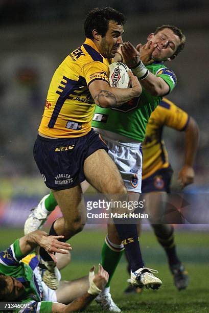 Wade McKinnon of the Eels palms off Todd Carney of the Raiders during the round 17 NRL match between the Canberra Raiders and the Parramatta Eels...