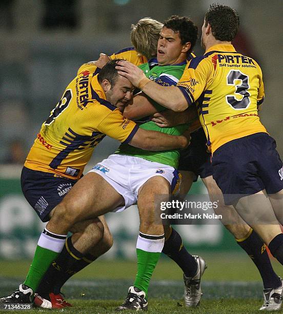 Dane Tilse of the Raiders is tackled during the round 17 NRL match between the Canberra Raiders and the Parramatta Eels played at Canberra Stadium on...