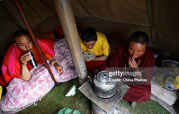 Monks and nuns eat meal in camp at the mountain foot of Tanggulashan Mountain during their pilgrimage on June 30, 2006 in Golmud City of Qinghai...