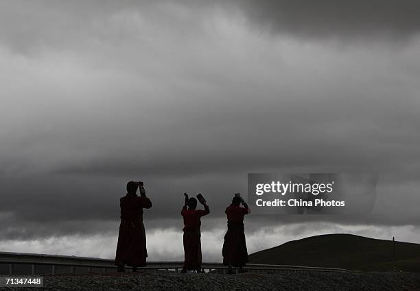 Monks and nuns pray along the road at the mountain foot of Tanggulashan Mountain during their pilgrimage on June 30, 2006 in Golmud City of Qinghai...