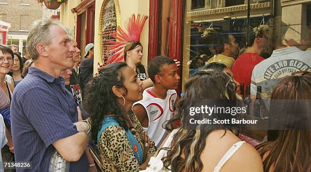 People watch the football on a television inside of a pub during the FIFA World Cup Germany 2006 Quarter-final match between England and Portugal on...