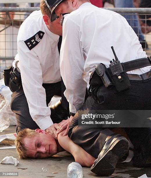 Man is detained by police officers in Trafalgar Square after the FIFA World Cup Germany 2006 Quarter-final match between England and Portugal on July...