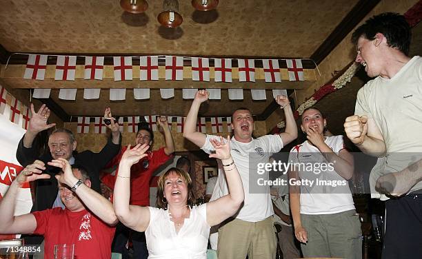 English football supporters react as their team score in the penalty shoot out during the FIFA World Cup quarter final match with Portugal on July 1,...