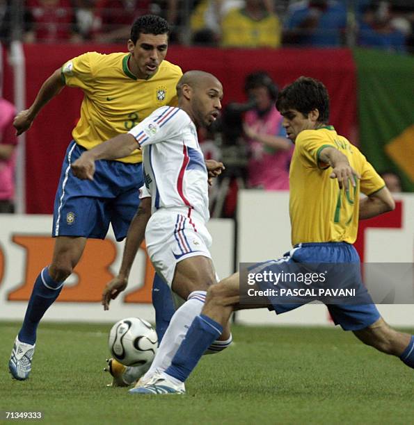 Frankfurt am Main, GERMANY: French forward Thierry Henry is challenged by Brazilian midfielder Juninho Pernambucano as Brazilian defender Lucio looks...