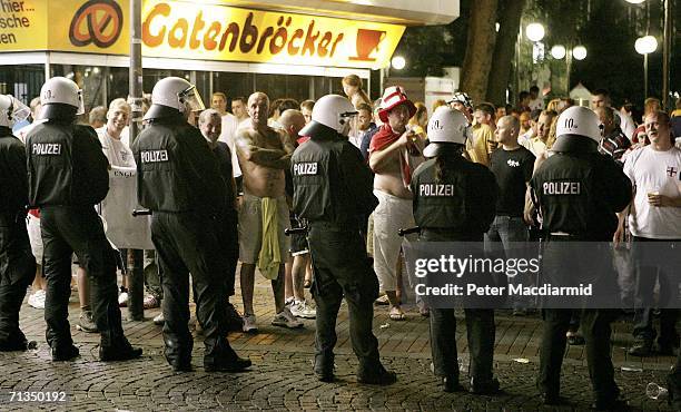 Football supporters stand behind a line of riot police on July 1, 2006 in Gelsenkirchen, Germany. England lost to Portugal in the World Cup quarter...
