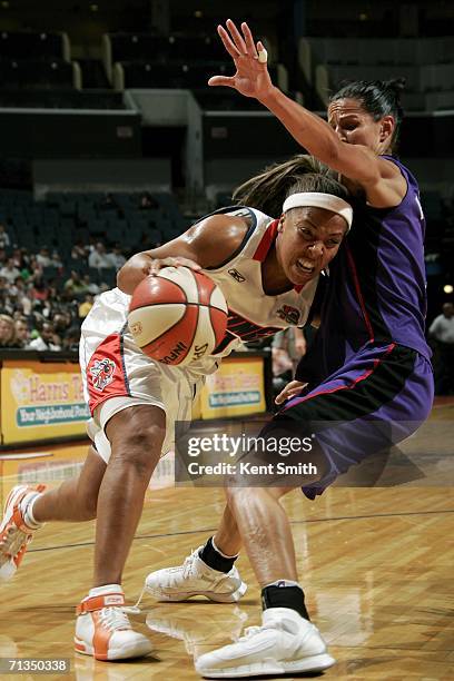 Helen Darling of the Charlotte Sting drives to the basket against Ticha Penicheiro of the Sacramento Monarchs on July 1, 2006 at the Charlotte...