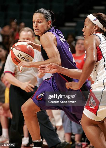 Ticha Penicheiro of the Sacramento Monarchs drives to the basket against Helen Darling of the Charlotte Sting on July 1, 2006 at the Charlotte...