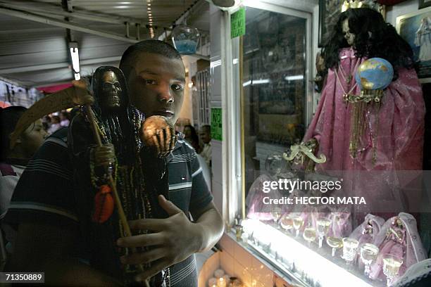 Man carries an efigie as he goes to the Romero's family altar in honor of Santa Muerte in the infamous Tepito neighborhood in Mexico City 01 July...