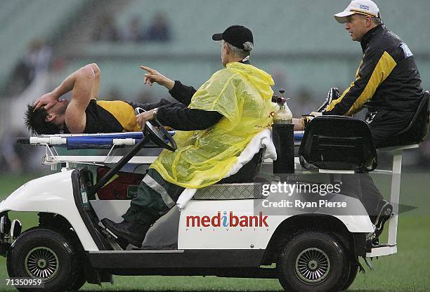 Chris Newman of the Tigers is driven from the ground after injuring his leg during the round thirteen AFL match between the Richmond Tigers and the...