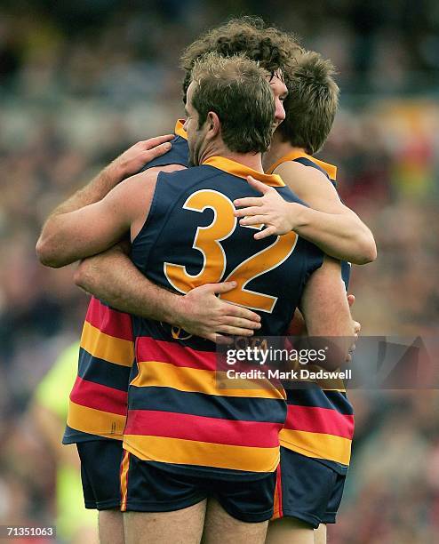 Mark Ricciuto and Brent Reilly of the Crows celebrate a goal with Ken McGregor during the round 13 AFL match between Adelaide and Geelong at AAMI...