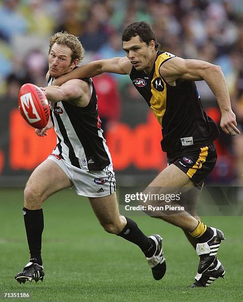 Andrew Kellaway of the Tigers competes for the ball against Ben Johnson for the Magpies celebrate a goal during the round thirteen AFL match between...