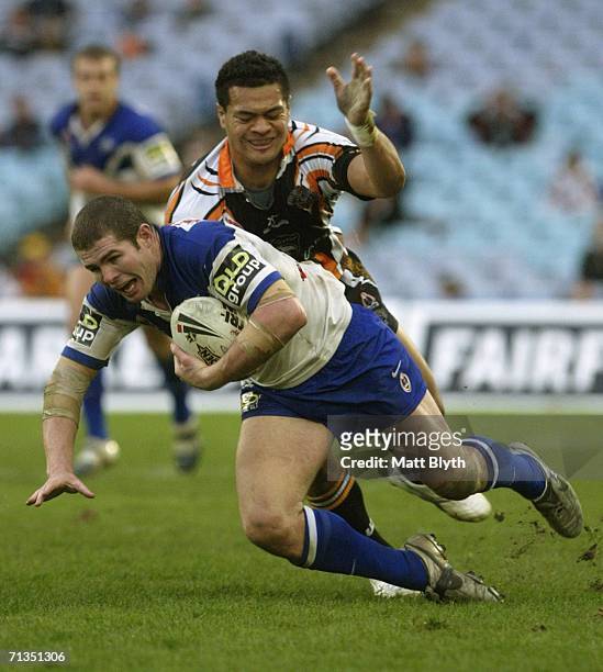 Andrew Ryan of the Bulldogs is tackled during the round 17 NRL match between the Wests Tigers and the Bulldogs at Telstra Stadium July 2, 2006 in...