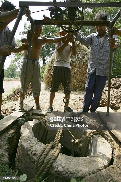 Farmers reinforce the wall of a newly dug well on June 30, 2006 in Lantian County of Shaanxi Province, north China. China is suffering a sustained...