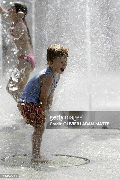 Children play in a fountain at the Parc Andre Citroen 02 July 2006 in Paris. According to Meteo France temperatures will rise from 05 July 2006 in...