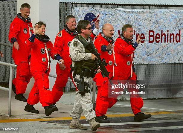 Mission Specialists Piers Sellers, Lisa Nowak, and Mike Fossum, Pilot Mark Kelly, and Commander Steve Lindsey, walk out of the Operations and...