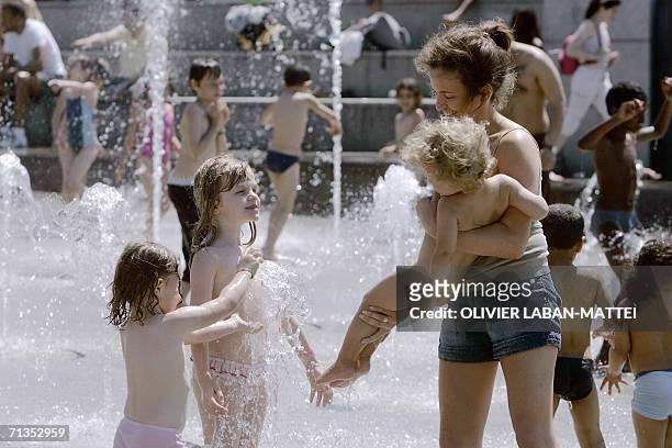Family play in a fountain at the Parc Andre Citroen 02 July 2006 in Paris. According to Meteo France temperatures will rise from 05 July 2006 in nine...