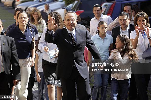 The presidential candidate Felipe Calderon of the National Action Party , waves to his supporters as he leaves his house to cast his vote, surrounded...