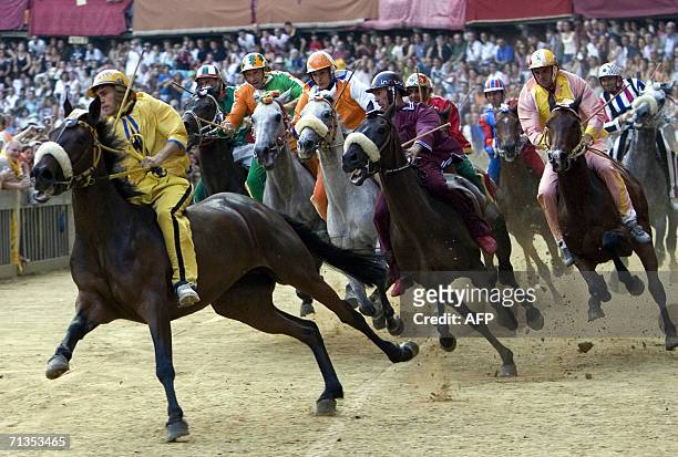 Riders from different Siena parrishes race in the traditional Palio di Siena horse race in Siena 02 July 2006. Italian jockey Andrea ''Brio'' Mari of...