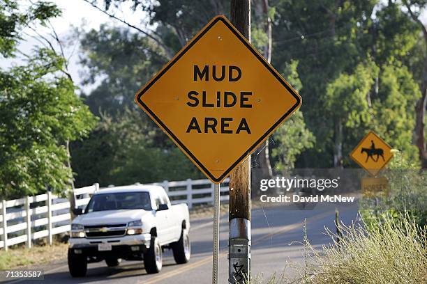 Signs warn of mud slides in the hillside community of Devore, which has suffered from flash floods and mud slides since a devastating wildfire...