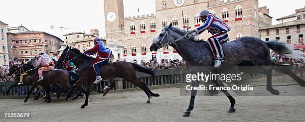 Jockeys and horses taking part in the "Palio di Siena" cross the starting line at the Piazza del Campo on July 2, 2006 in Siena, Italy. The annual...