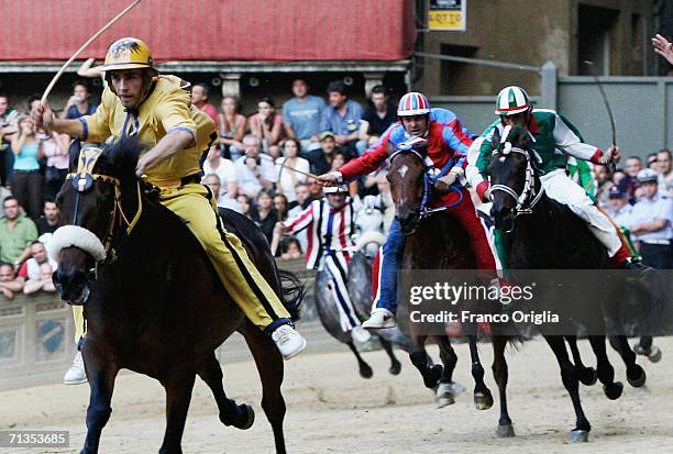 Jockeys and horses taking part in the "Palio di Siena" cross the starting line at the Piazza del Campo on July 2, 2006 in Siena, Italy. The annual...