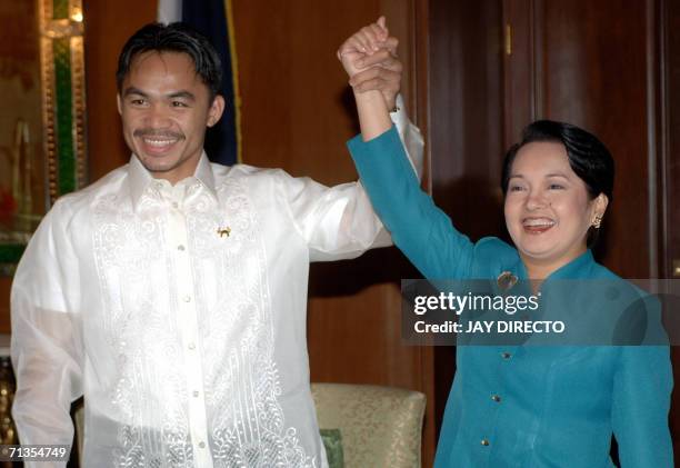 International super featherweight champion Manny Pacquiao raises the hand of President Gloria Arroyo after the Filipino boxer was conferred the...