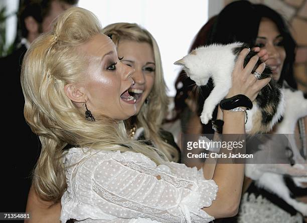 Kimberly Wyatt holds up a cat whilst looking around the pet section of Harrods as The Pussy Cat Dolls open the Harrods Summer sale on July 3, 2006 in...